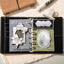 Open planner with decorative pages on a textured surface with a pen and notebook.