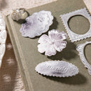 Decorative metal dies on a textured surface with 'Denali' branding.