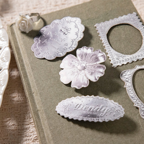 Decorative metal dies on a textured surface with 'Denali' branding.