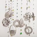 Decorative hanging mobile with silver swans, flowers, and leaves on a white background