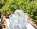 Clear crystal-like objects on a reflective surface with a blurred green background
