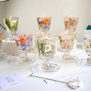 Set of floral candle holders with candles on a white surface.