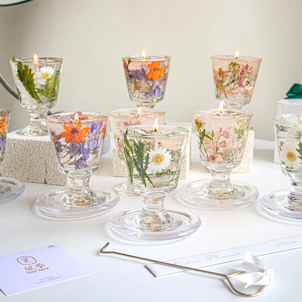Set of floral candle holders with candles on a white surface.
