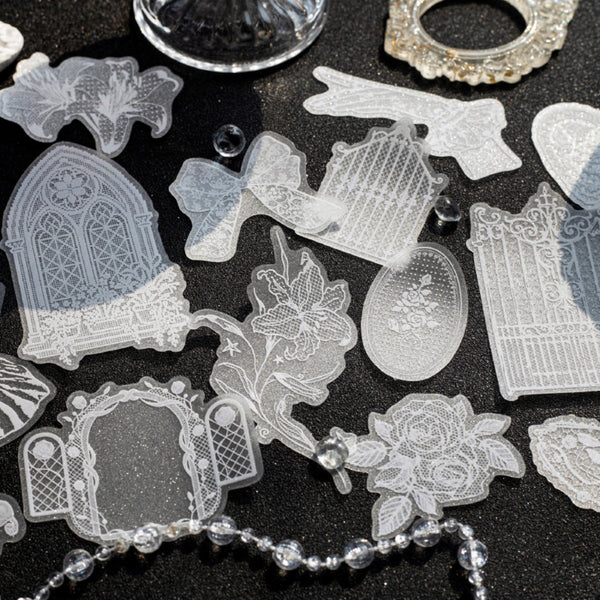 A collection of clear, laser-cut acrylic or glass craft stamps featuring gothic tombstone, rose, and ornate frame designs, arranged on a dark textured background.
