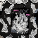 A clear stamp set sheet labeled 'Fate Old' and 'Dream' by the brand 'Lily Flower' is displayed on a textured black background, surrounded by matching white lace cutout embellishments.