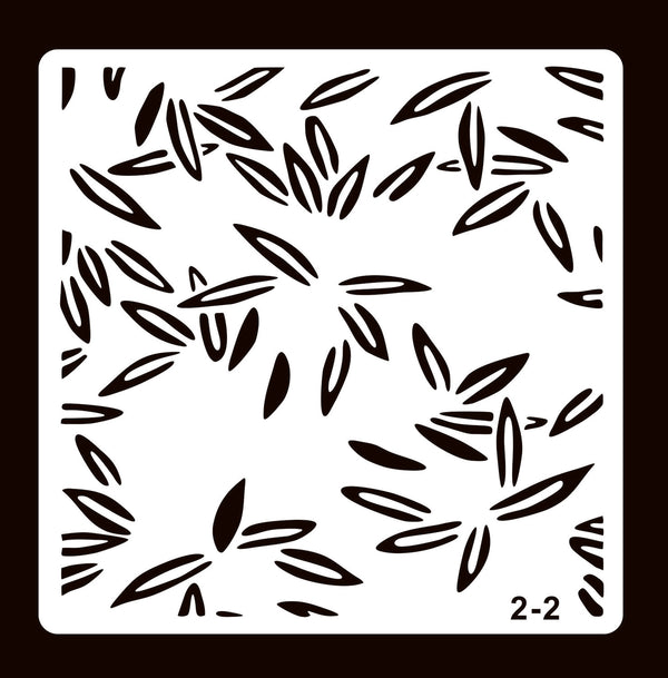 A square stencil template with a repeating pattern of black leaf-like cutouts on a white sheet, shown against a dark brown background. The number '2-2' is printed in the bottom right corner.