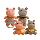 Four crocheted hippo toys in different colors on a white background
