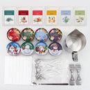 A wax candle making kit laid out on a white background, including printed label cards, round tin containers with Christmas-themed labels, metal wicks, a double-ended spatula, and a stainless steel measuring cup.
