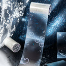 Roll of decorative paper with heart designs on a dark background
