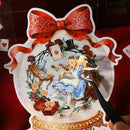 Decorative plate with Alice in Wonderland design, featuring a red bow at the top.