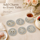 Six round pearl coasters with animal designs arranged on a beige table alongside a teacup, cake, macarons, and flowers. Text at the top reads 'Add Charm to Every Table'.