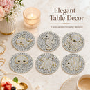 Six round pearl coasters with gold and white sea creature designs are arranged on a marble tabletop with a candle, flowers, and dessert props. Text reads 'Elegant Table Decor' and '6 unique pearl coaster designs'.