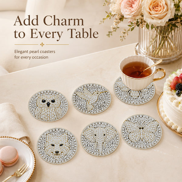 Six round pearl coasters with animal face designs (owl, bird, fox, elephant, bear, cat) arranged on a beige table alongside a teacup, cake, macarons, and flowers. Text overlay reads 'Add Charm to Every Table'.