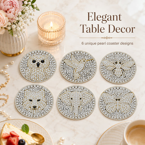 Six round pearl-embellished table coasters with animal motifs (owl, bird, bee, cat, elephant, butterfly) arranged on a marble surface with lifestyle props including a candle, flowers, and a cup of coffee. Text reads 'Elegant Table Decor' and '6 unique pearl coaster designs'.
