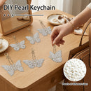DIY pearl keychains shaped like butterflies, displayed on a wooden table with a hand holding one keychain. The image includes text overlays 'DIY Pearl Keychain' and 'Pearls of different sizes', along with a close-up circular inset showing the pearl details.