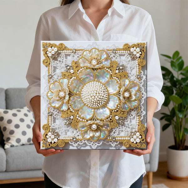 Person holding a decorative square with floral patterns and gold accents in a living room setting.