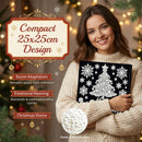A woman in a cream knit sweater holds a black rectangular Christmas ornament or keepsake box decorated with white snowflakes and a white tree design. The image includes promotional text reading 'Compact 25x25cm Design' and holiday-themed background lights and pine branches.