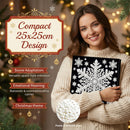 A woman in a cream knit sweater holds a black compact ornament carrier decorated with a large white snowflake design. The image includes promotional text highlighting the compact 25x25cm design, Christmas theme, and pearl embellishments, with a blurred festive background of lights and pine branches.