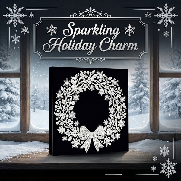 A square black canvas or box featuring a white glittery snowflake and wreath design, displayed in front of snowy window panes with the text 'Sparkling Holiday Charm' above it.