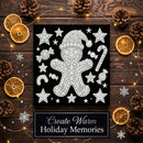 A square black holiday art print featuring a white glitter-textured gingerbread man surrounded by stars, candy canes, and ornaments, styled on a dark wood background with dried orange slices, pinecones, fairy lights, and snowflake decorations. A banner at the bottom reads 'Create Warm Holiday Memories'.