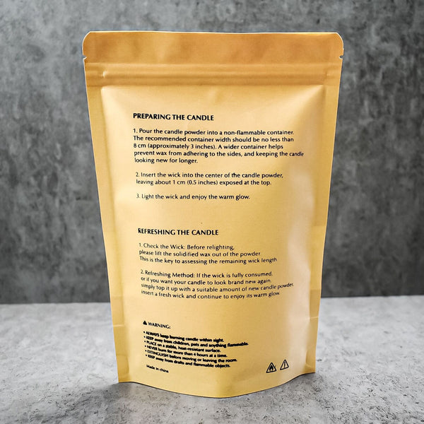 A gold resealable pouch showing the back side with printed candle preparation and usage instructions, photographed on a gray textured surface.