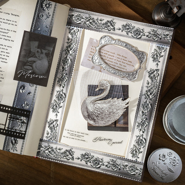 Decorative book with embossed design and swan illustration on a wooden surface