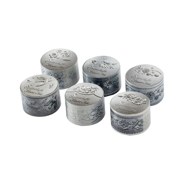 Set of six silver containers with floral designs on a white background