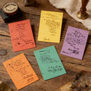 Five colorful letters on a wooden surface with vintage stamps and stationery.