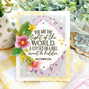 Decorative card with floral design and inspirational quote, surrounded by plants and decorative items.