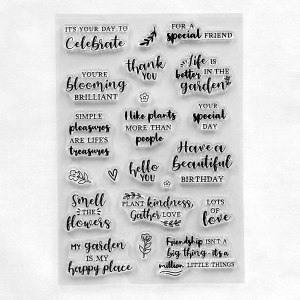 A sheet of clear acrylic or plastic stamps with black printed phrases and small decorative motifs, photographed on a plain white background.