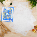 Clear stamp sheets with a decorative card on a wooden surface.