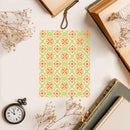 Patterned card with orange and green flowers on a white surface with books and dried flowers.