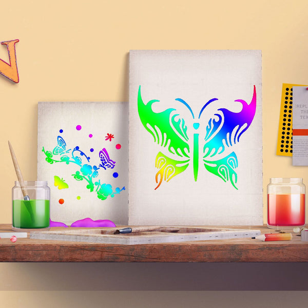 Two colorful butterfly art prints displayed on a wooden shelf, surrounded by paint jars, brushes, and a candle against a warm beige wall.
