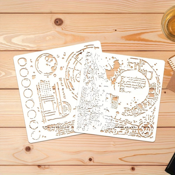Two white laser-cut metal stencil sheets with intricate celestial and architectural designs, displayed on a light wood plank background.
