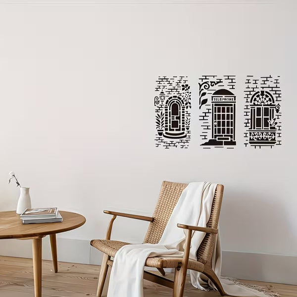 Three black vinyl wall decals depicting London-themed storefronts are displayed on a light beige wall in a styled room setting with a wooden chair, side table, and white throw blanket.
