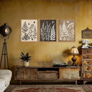 Vintage-style living room with wooden furniture, framed botanical prints, and decorative items.