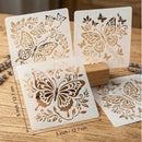 Four white square stencil sheets with butterfly and floral cutout designs displayed on a wooden surface, with one sheet showing dimension markings of 5 inch / 12.7 cm.