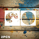 Two white circular stencil templates displayed on a rustic, paint-splattered wooden background, with '2PCS' text in the bottom-left corner.