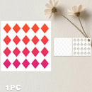 A sheet of diamond-shaped sticker decals with a gradient color scheme from orange to red and pink, displayed next to two sample cutouts on a textured off-white background with dried flowers.
