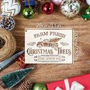 A rectangular wooden sign with a Christmas tree truck graphic and the text 'FARM FRESH CHRISTMAS TREES' and 'PINE • SPRUCE • FIR' is shown on a rustic wood surface surrounded by holiday ornaments, pinecones, twine, a small tree, and wrapped gifts. Measurement labels '28cm/11in' and '20cm/7.