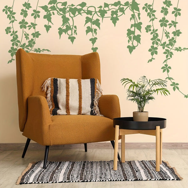 A mid-century modern wingback armchair in mustard yellow fabric, styled with a striped throw pillow, next to a small black and wood side table with a potted plant. The scene is set against a beige wall decorated with green ivy wall decals and a black-and-white patterned rug.