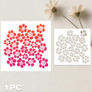 Two square sheets of small floral cutout stickers or decals on a light textured background, with two dried white flowers above. One sheet shows solid red-to-pink flowers, and the other shows white floral cutouts.