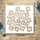 A white square stencil or template with a repeating floral cutout pattern, shown on a wood surface with dimension lines indicating 15.3 cm by 15.