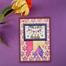 A handmade greeting card with a whimsical 'Make a Wish' cupcake design, styled on a purple background with a yellow flower prop.