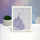 A square white card featuring a lavender line-art illustration of a castle over a background of cursive handwriting, displayed on a white surface next to a small potted succulent.