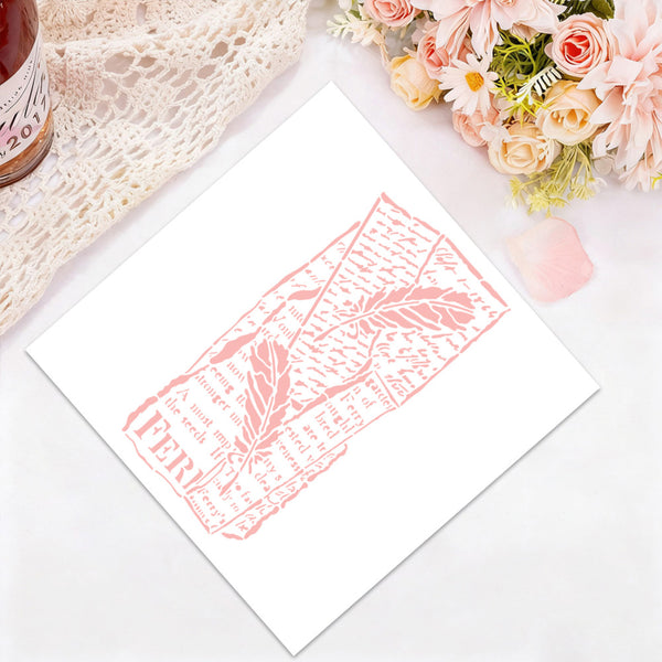 A white art print featuring a pink linocut-style illustration of a feather and text, styled on a white surface with a lace cloth, flowers, and a small bottle in the corners.