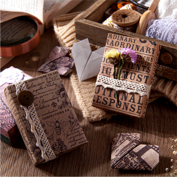 Decorative envelopes with vintage-style text and patterns on a wooden surface.