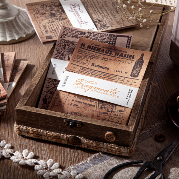 Wooden box with vintage-style business cards and documents on a wooden surface.