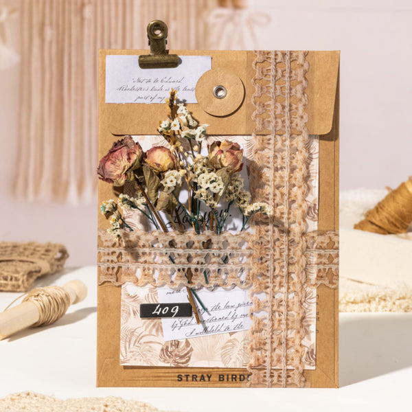 Decorative card with dried flowers and a clip on a textured surface