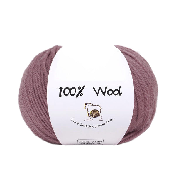 A ball of dusty mauve purple 100% wool yarn with a white paper label that reads '100% Wool' and features a small sheep illustration, set against a plain white background.